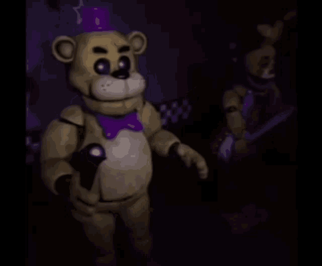 a teddy bear with a purple hat is standing in a dark room .