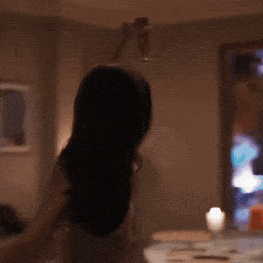 a woman is holding a glass of wine in her hand in a room .