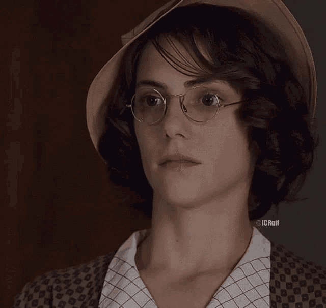 a close up of a woman wearing glasses and a hat with icrgif written on the bottom