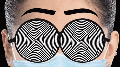a woman wearing a mask and hypnotic glasses looks at the camera