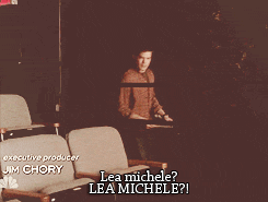 a blurred image of a man sitting in an auditorium with lea michele written on the bottom