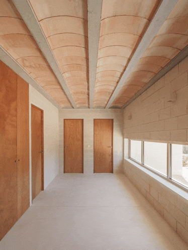a hallway with wooden doors and a ceiling made of concrete