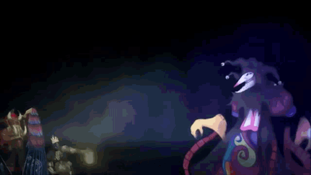 a group of people are standing next to each other in a dark room in front of a giant clown .