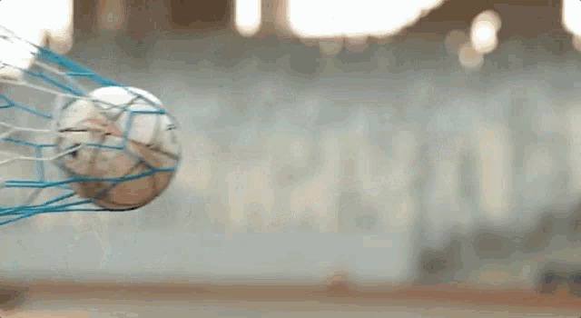 a soccer ball is going through a net and into the goal