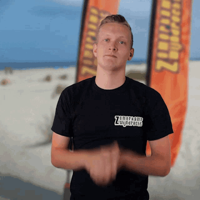 a young man wearing a black shirt that says zomerkamp zwijndrecht