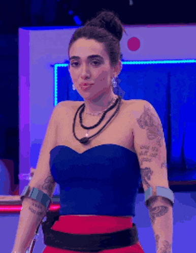 a woman in a blue top and red skirt has a tattoo on her arm that says ' i love you '