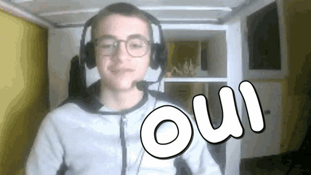 a young man wearing headphones and glasses has the word oui written on his face