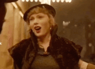 a woman wearing a hat and a fur coat is standing in a room .