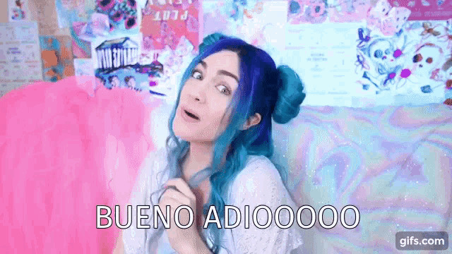 a girl with blue hair is sitting on a pink pillow and says bueno adio00000