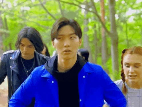 a man in a blue jacket is standing next to a woman in a white dress .