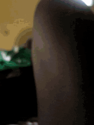 a close up of a person 's arm with a green shirt behind them .