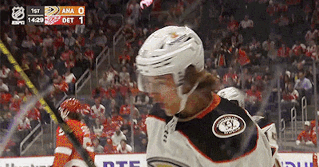 a hockey player stands on the ice with the scoreboard showing ana 0