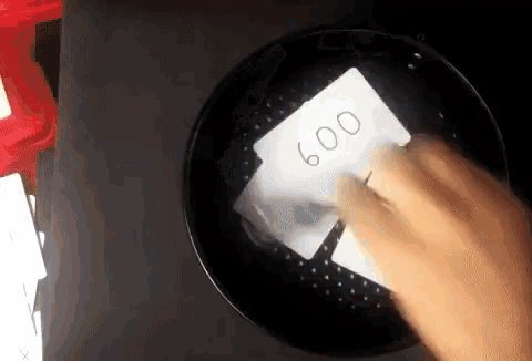 a hand is holding a piece of paper with the number 600 on it