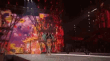 a blurred image of a woman walking down a runway