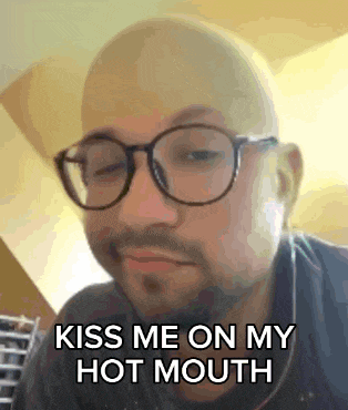 a bald man with glasses and a beard is saying `` kiss me on my hot mouth '' .