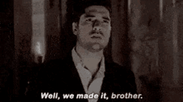 two men are standing next to each other and one of them is talking to the other .