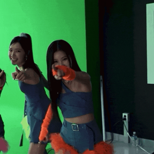 a woman in a blue crop top is pointing at something