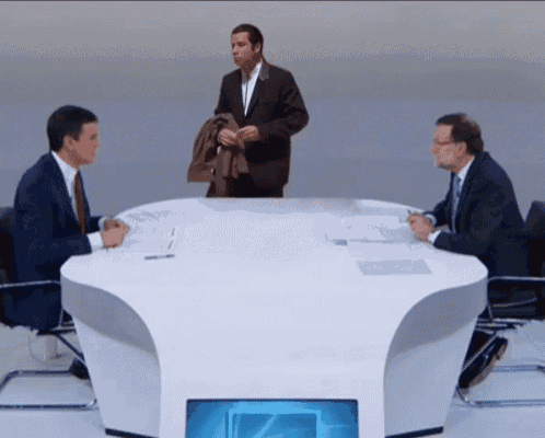 a man in a suit stands between two men at a table