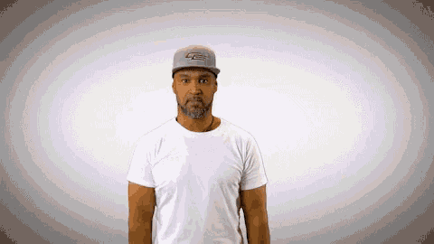 a man wearing a white shirt and a hat with the letter le on it