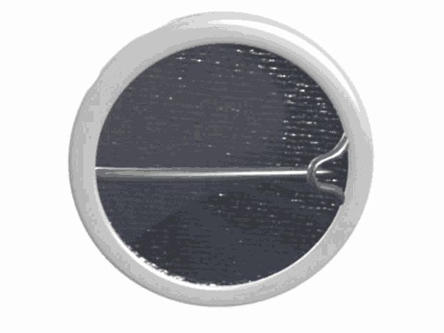 a white circle with a metal pin on it