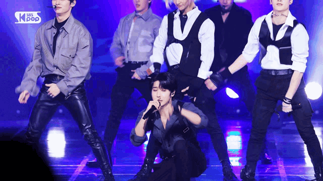 a group of young men are performing on a stage with the words sbs kpop on the bottom