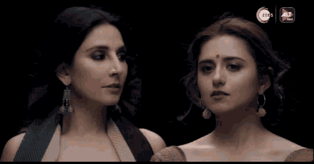 two women are standing next to each other with a ztbs logo in the background