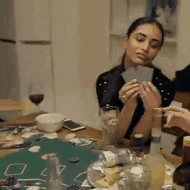 a woman is playing a game of cards at a table .