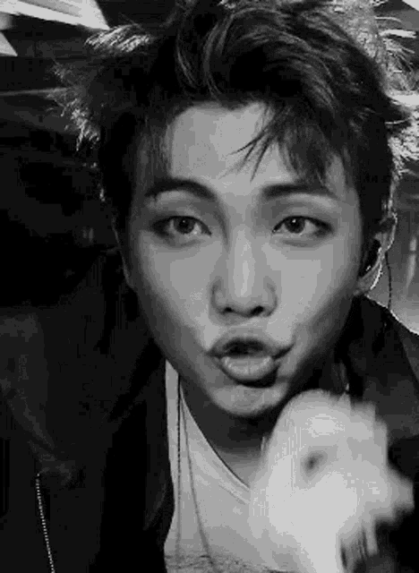 a black and white photo of a man making a funny face .