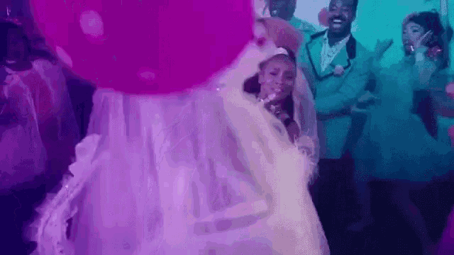 a bride and groom are dancing at a wedding reception with their bridesmaids .
