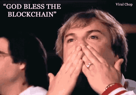 a man with a ring on his finger is covering his mouth with his hands while a woman says " god bless the blockchain " .