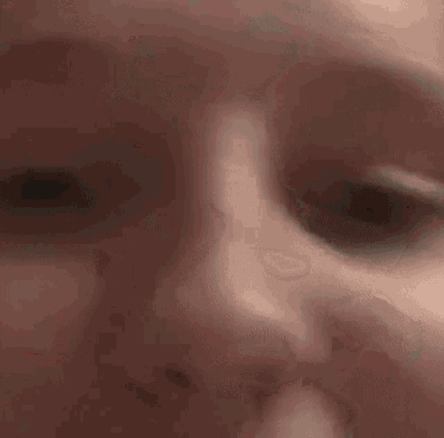 a close up of a woman 's face with a hand on her chin .