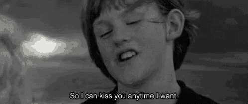 a black and white photo of a boy with the words `` so i can kiss you anytime i want ''