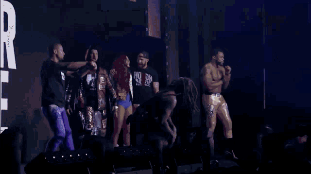 a group of wrestlers are standing on a stage with one wearing a shirt that says ho oh on it