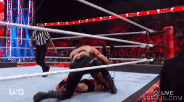 two men are wrestling in a ring with a referee in the background and a gifrun.com logo on the bottom