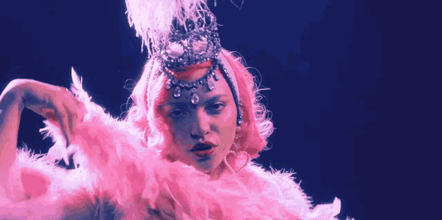 a woman with pink hair is wearing a pink feather boa