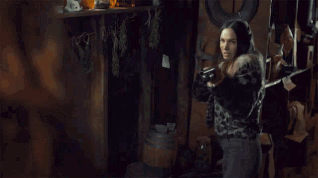 a woman holding a gun with the words " you basic bitch " behind her