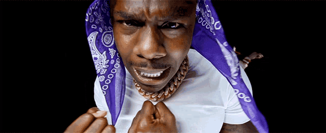 a man wearing a white shirt and a purple bandana that says 00 on it