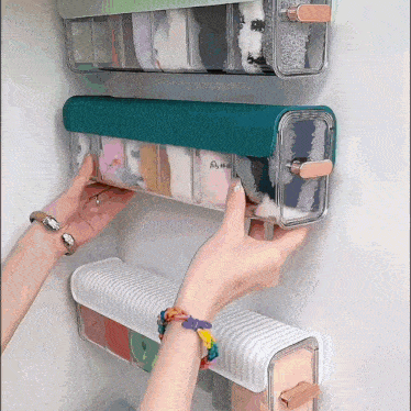 a person is reaching into a clear container with a blue lid that says ' socks ' on it