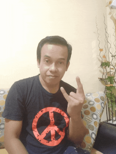 a man in a black shirt with a peace sign on it
