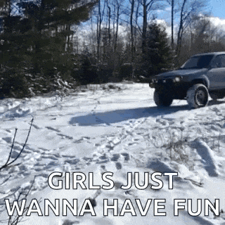 a car is driving down a snowy road with the words `` girls just wanna have fun '' .