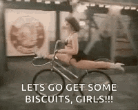 a woman is riding a bike with her legs crossed and says `` lets go get some biscuits , girls ! ''