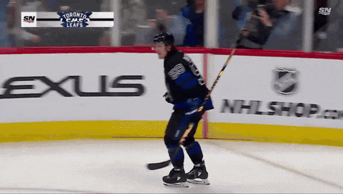 a hockey player on the ice with a toronto leafs logo in the background