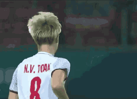 a soccer player wearing a white jersey with the number 8 on the back