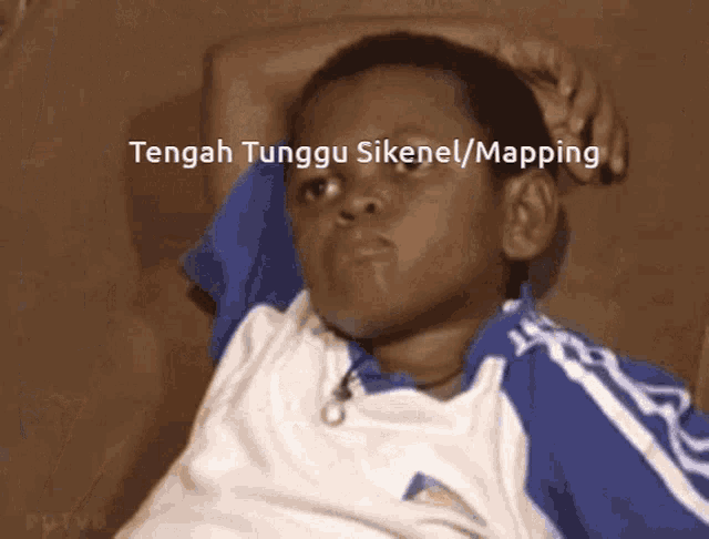 a young boy laying on a couch with the words tengah tunggu sikenel / mapping written above him