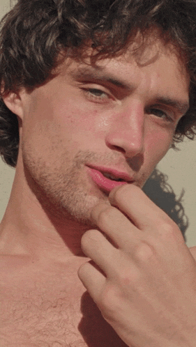 a close up of a man 's face with his finger in his mouth