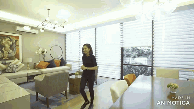 a woman is dancing in a living room with the words made in animotica on the bottom