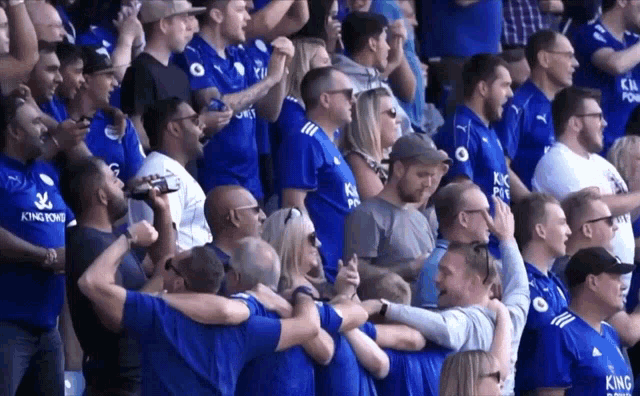 a crowd of people wearing blue shirts with king power written on them