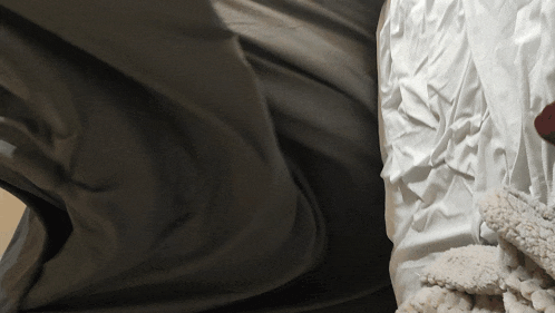 a person laying on a bed with white sheets