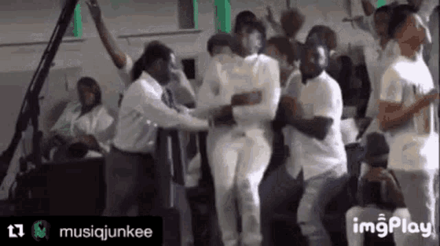 a group of people in white shirts are dancing in a church .