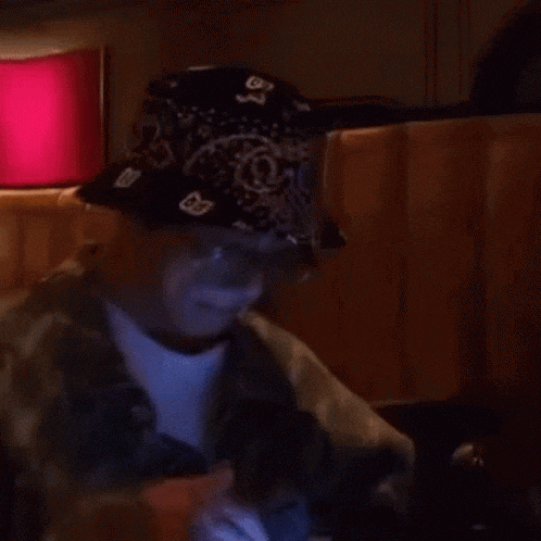 a man wearing a bandana and a bucket hat with the letter o on it